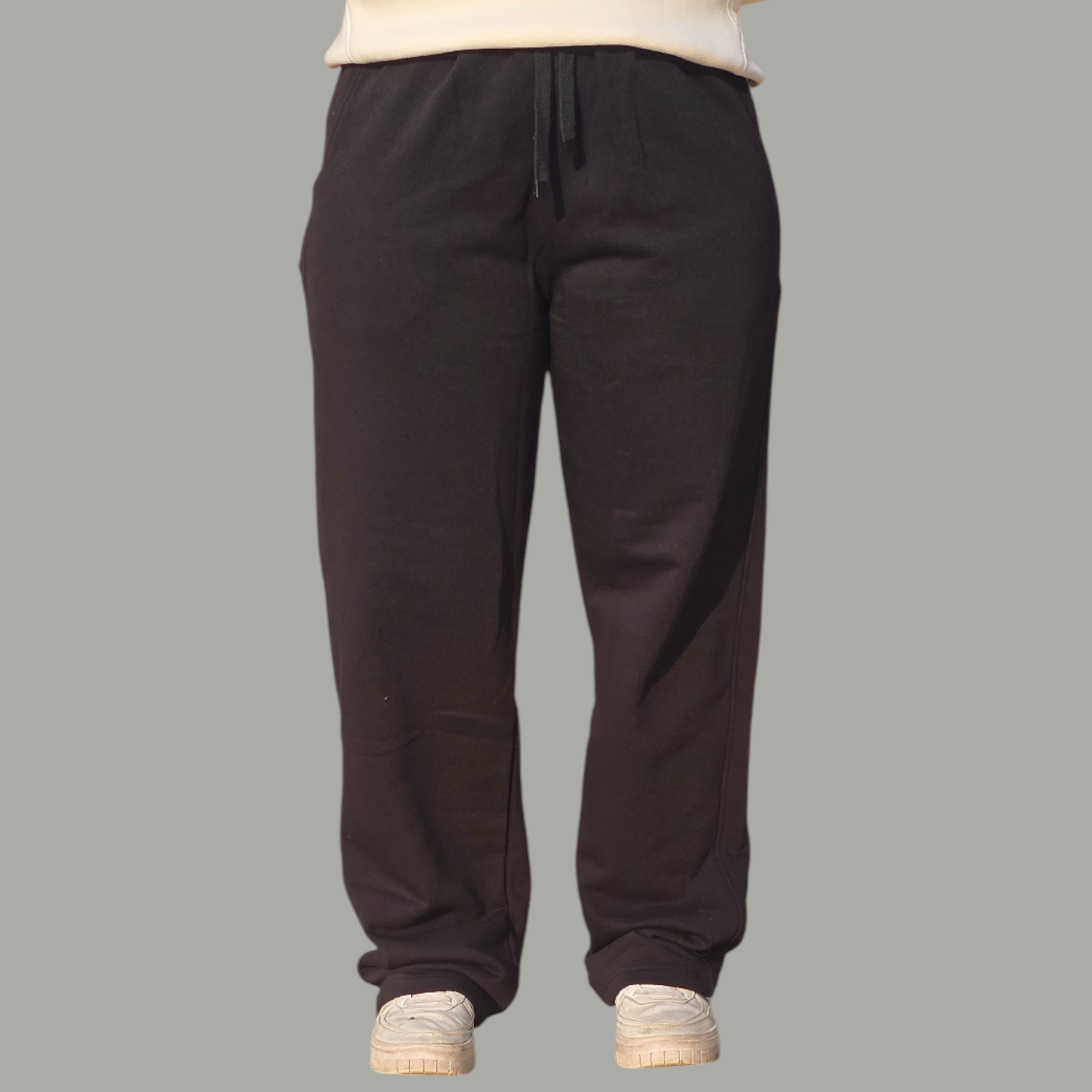 Black pants worn by a person on a gray background