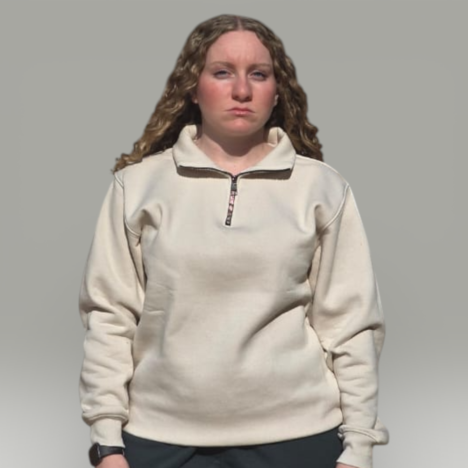 Person wearing a beige fleece pullover with a zipper on a gray background