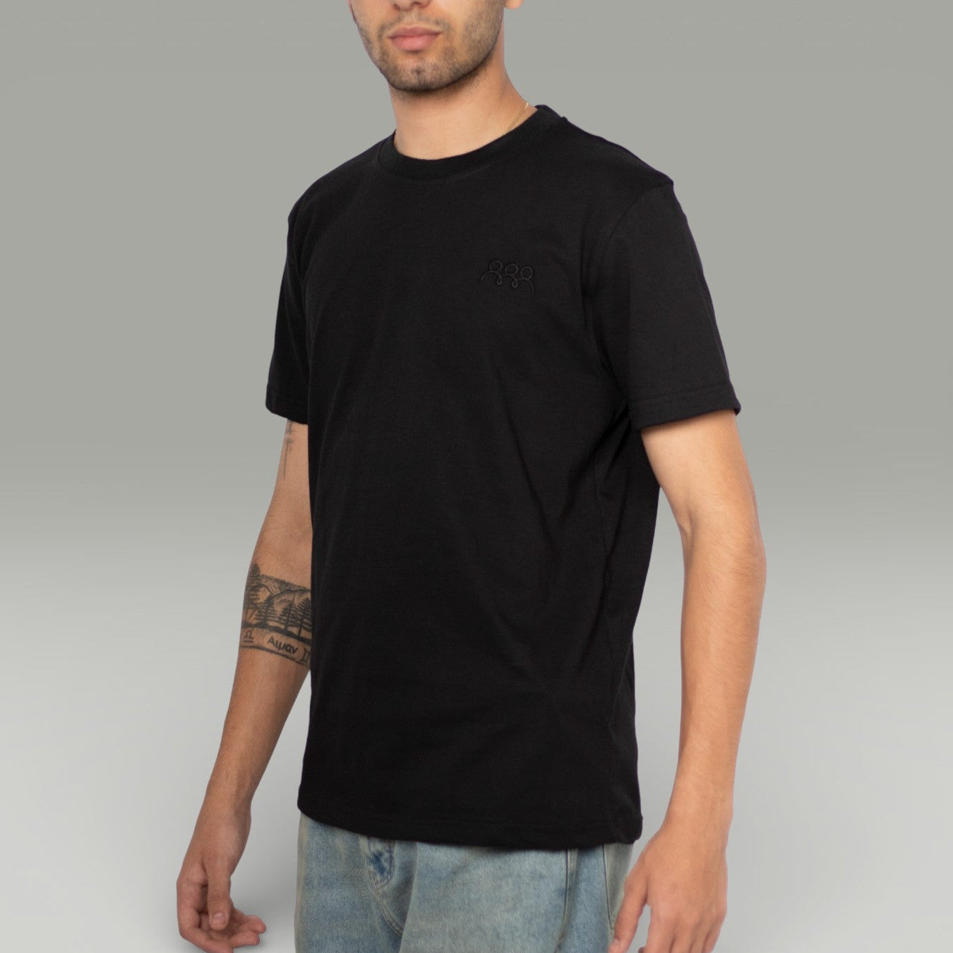 Person wearing a black t-shirt on a gray background