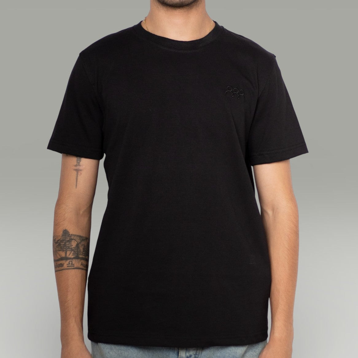 Person wearing a black t-shirt on a gray background
