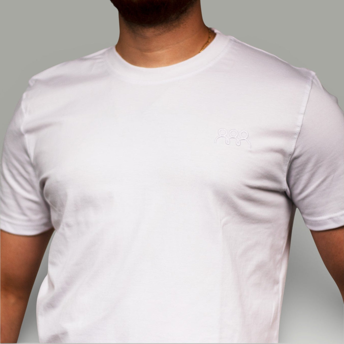 White t-shirt worn by a person on a gray background