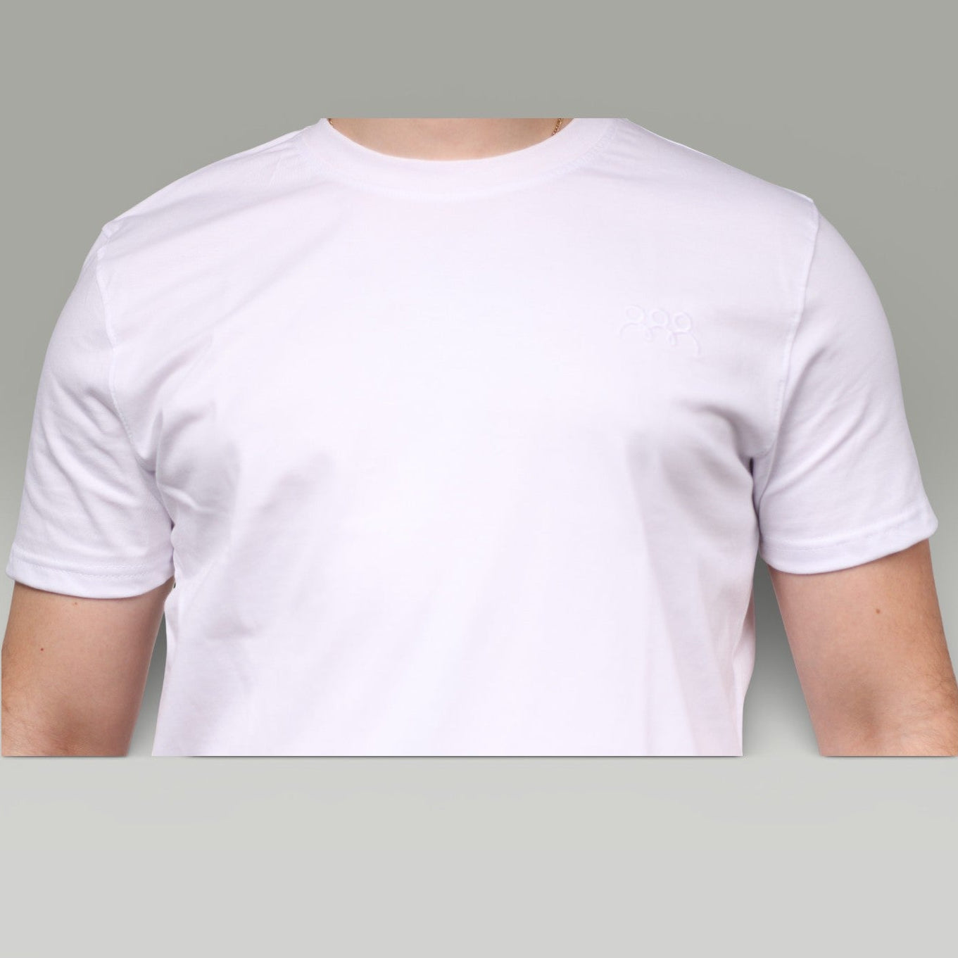 White t-shirt worn by a person on a gray background
