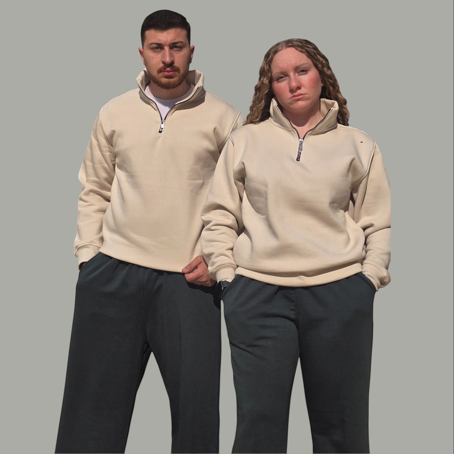 AnyWear unisex beige quarter-zip pullover sweatshirt with stand-up collar worn by a man and woman.