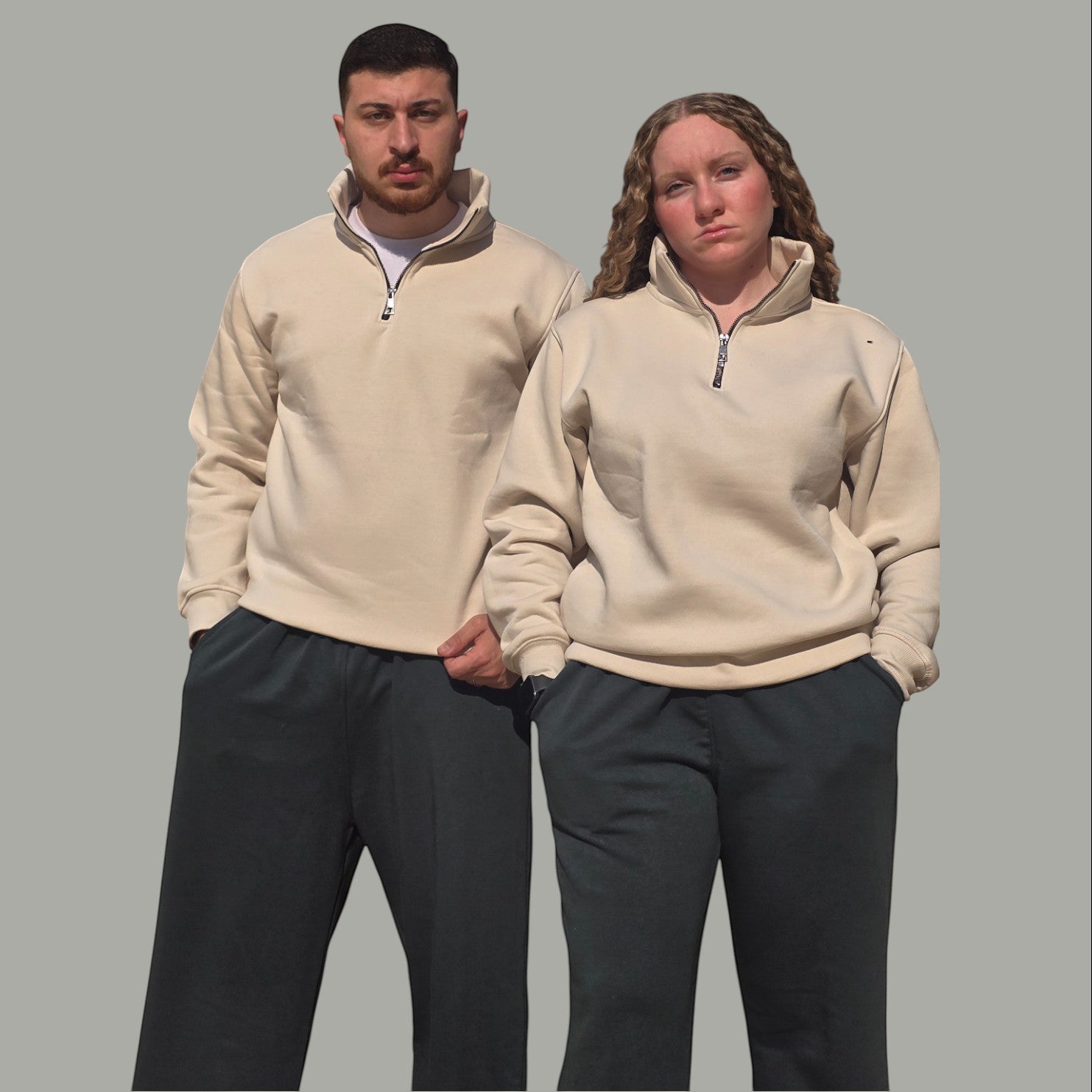 AnyWear unisex beige quarter-zip pullover sweatshirt with stand-up collar worn by a man and woman.