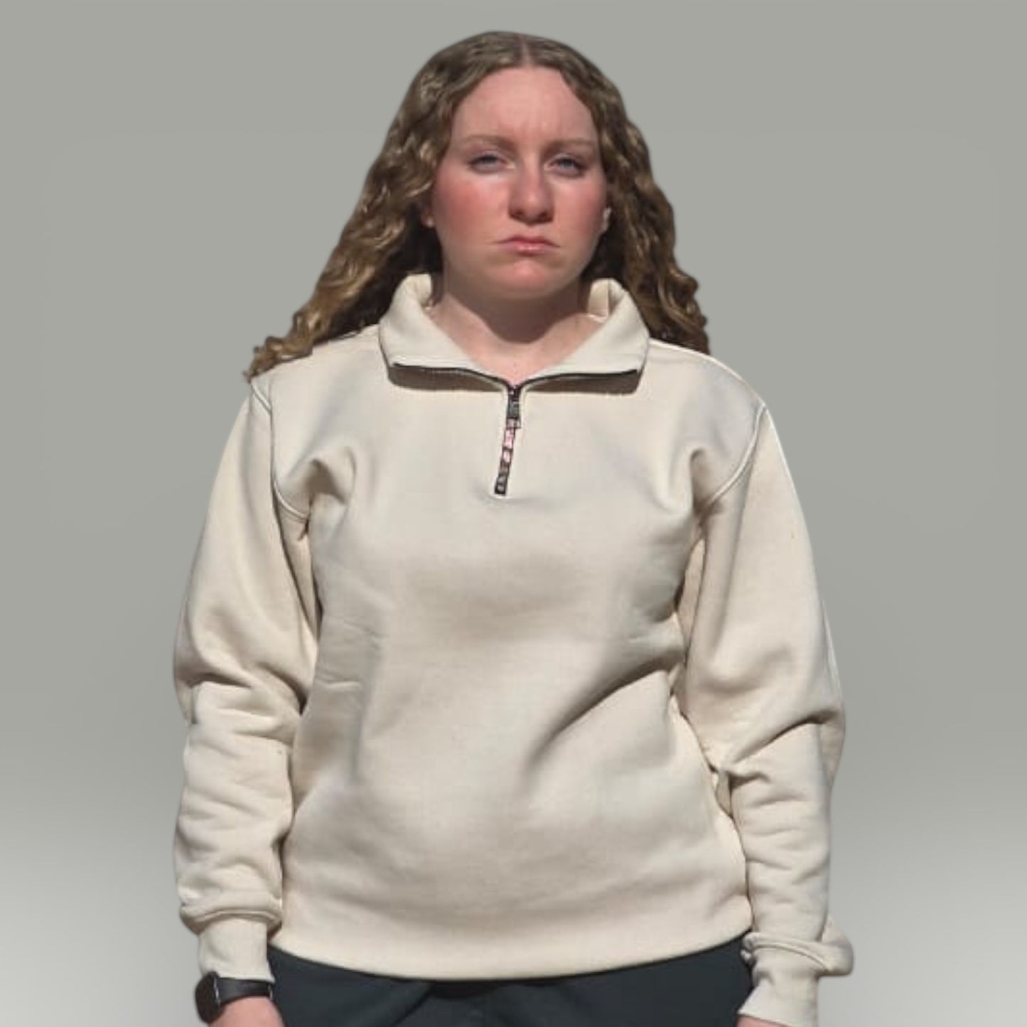 Model wearing an AnyWear unisex cream quarter-zip pullover sweatshirt with a stand-up collar and ribbed cuffs.
