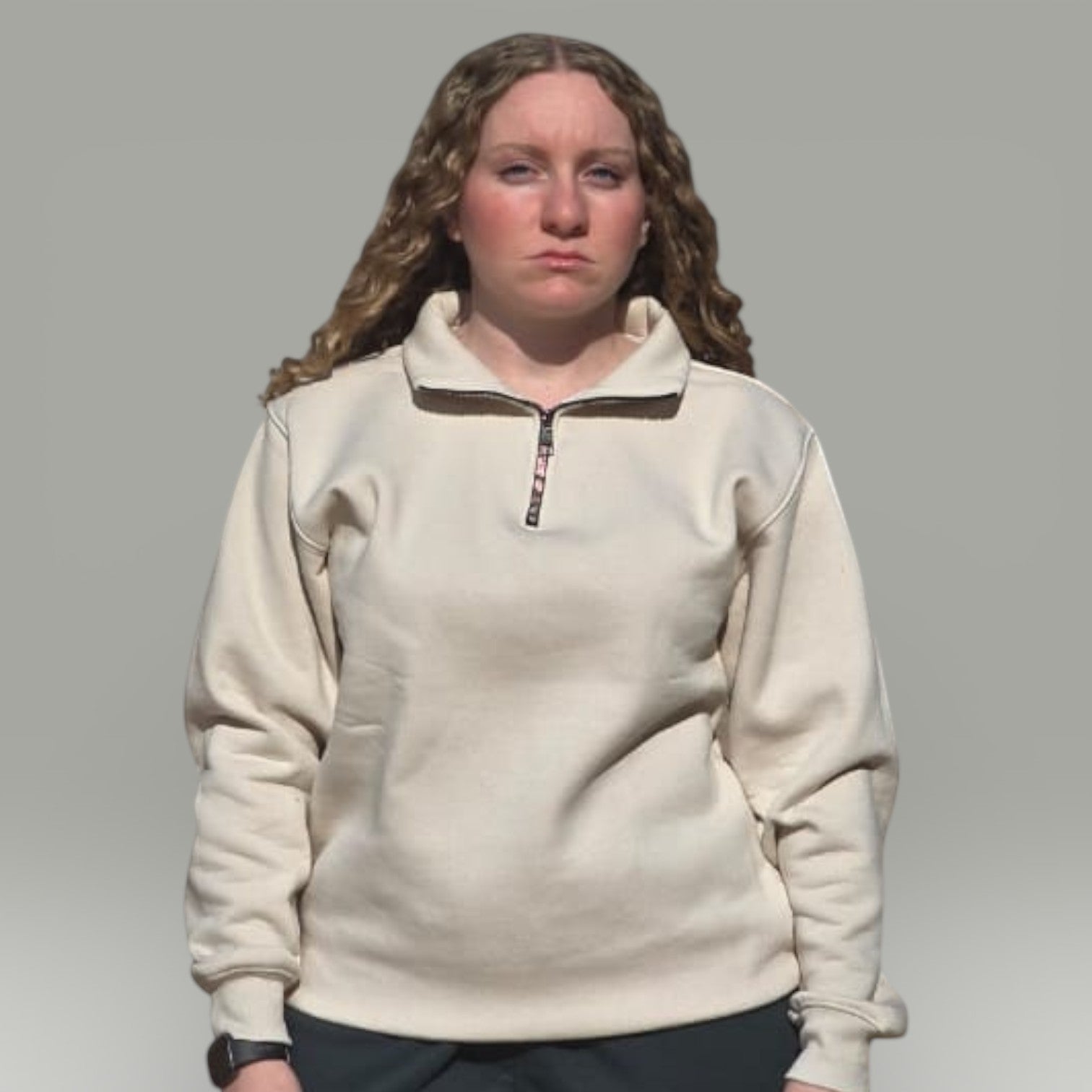 Model wearing an AnyWear unisex cream quarter-zip pullover sweatshirt with a stand-up collar and ribbed cuffs.