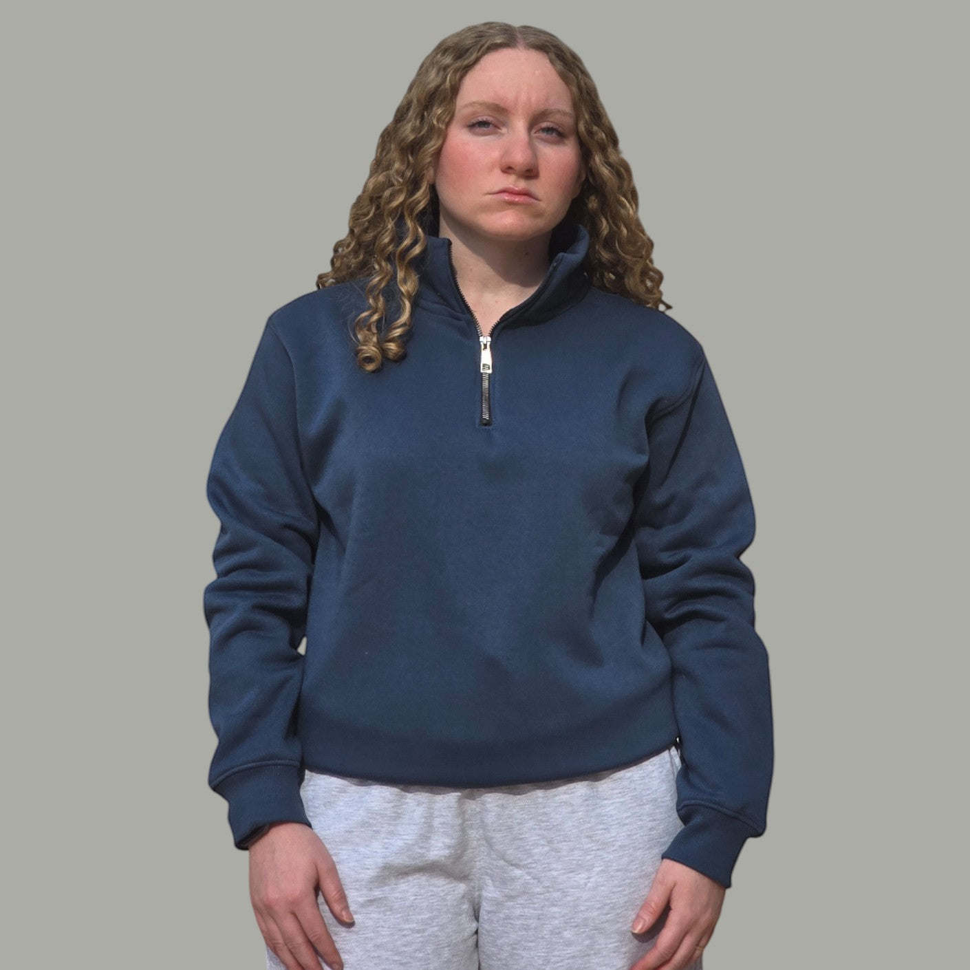 AnyWear unisex navy blue quarter zip pullover sweatshirt with a stand-up collar and metal zipper worn by a woman.